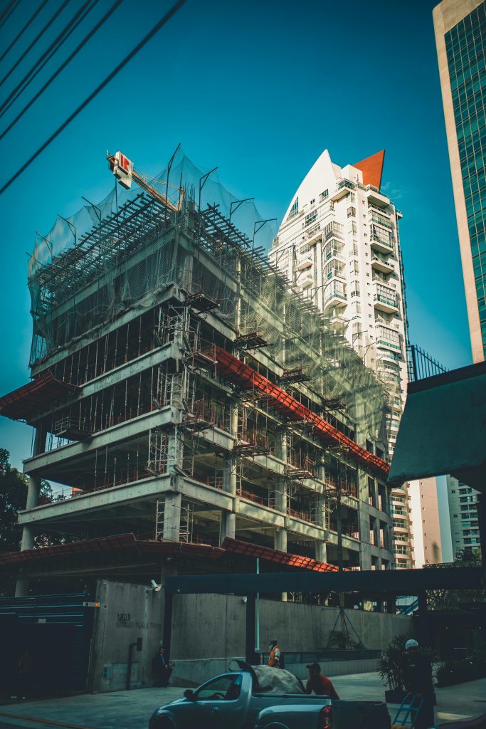 pexels-photo-2100681-2100681 High-rise building under construction with scaffolding and crane in urban cityscape.